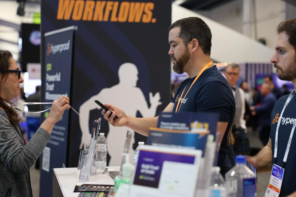 Hyperproof team interacting with people in their booth at RSAC